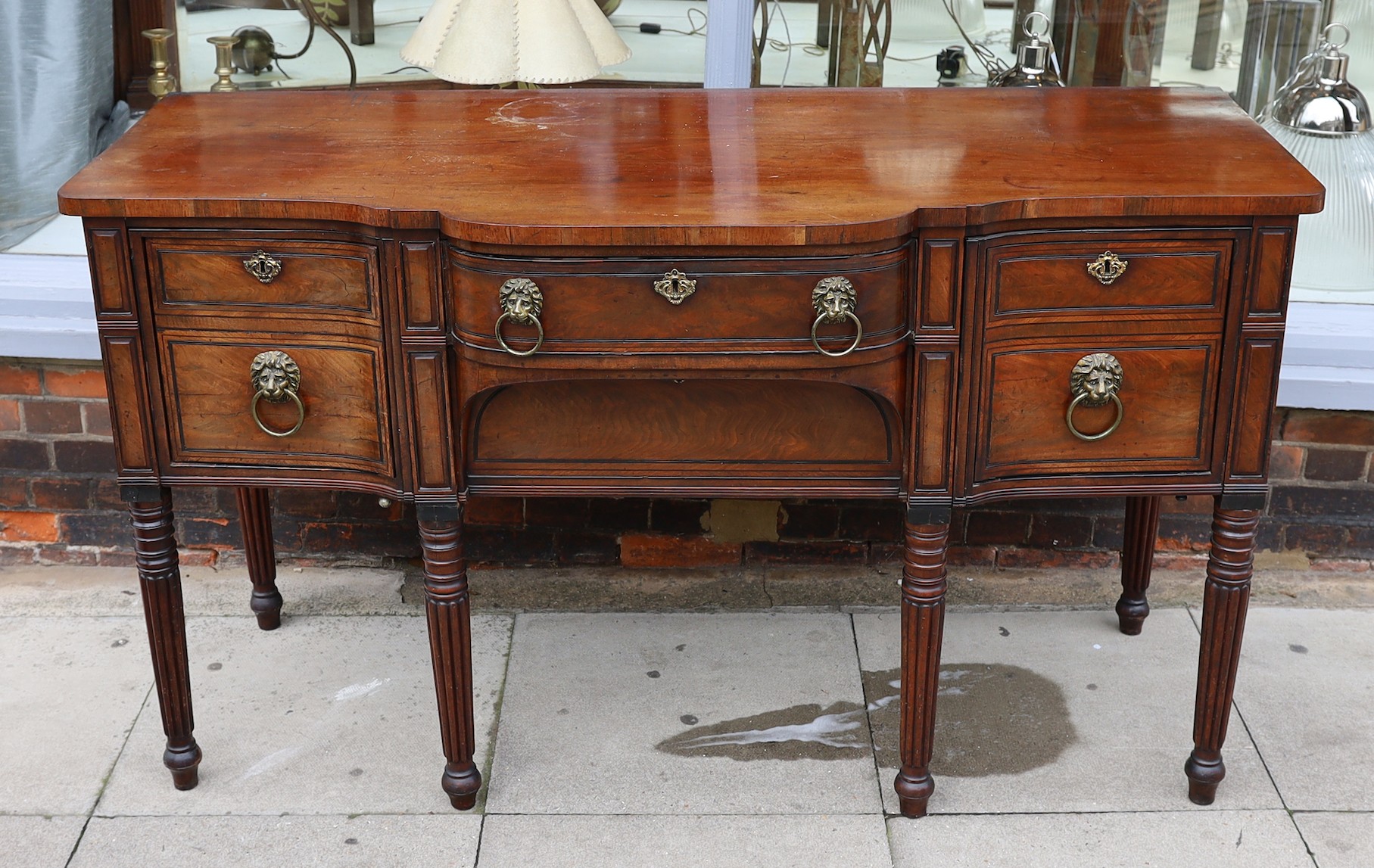A Regency ebony strung mahogany breakfront sideboard, each deep drawer with ‘secret’ revolving cellaret compartment, centred with two long drawers, on ring turned fluted and tapered legs, width 167cm. depth 69cm. height